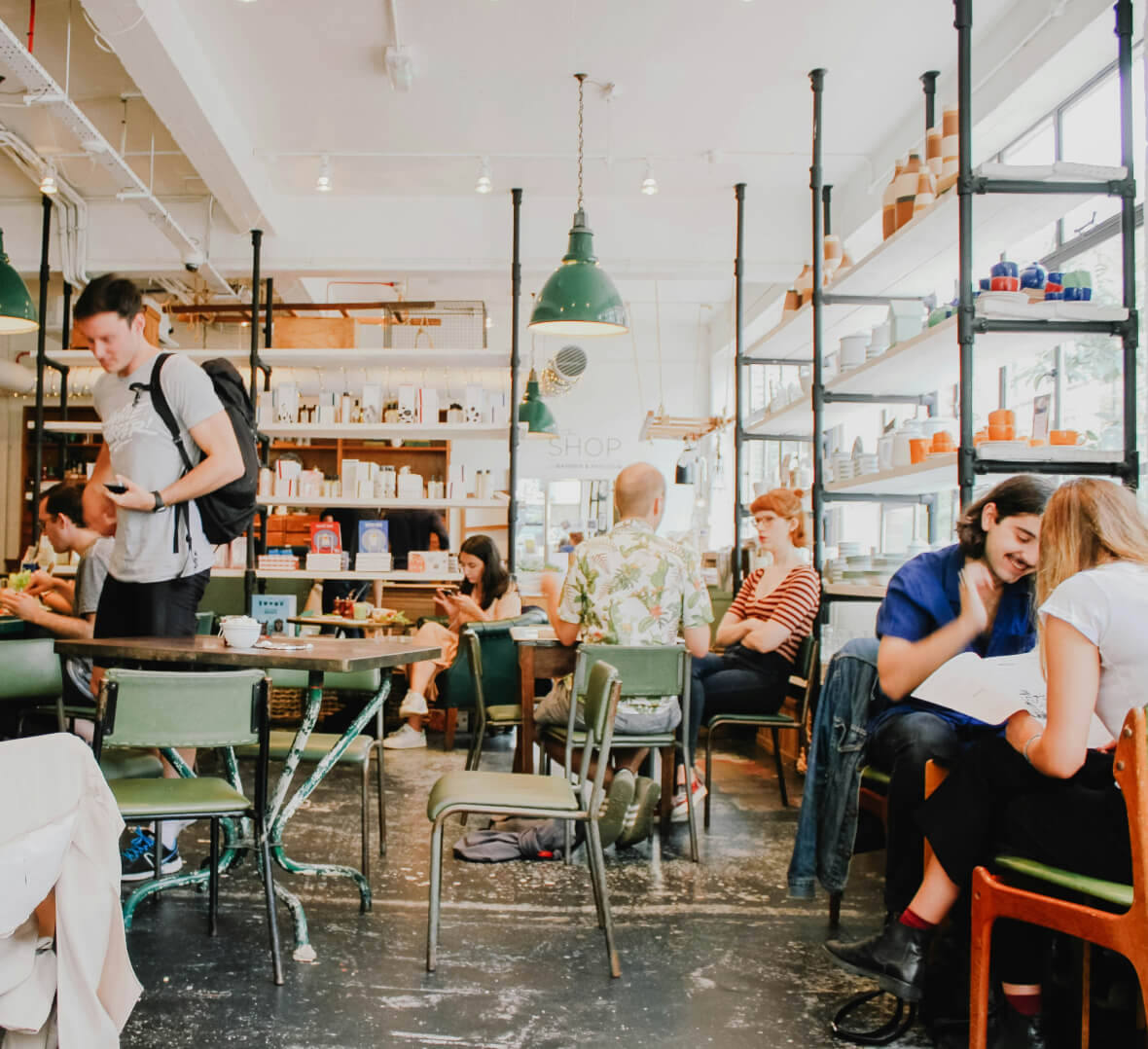 a small bistro full of people sitting and eating and socializing